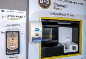 a machine with a pay phone in a box at B&B HOTEL La Rochelle Angoulins in Angoulins-sur-Mer