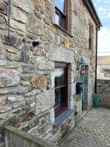 a stone building with a window on the side of it at 9A Viaduct Cottage - the cosiest bolthole in the SW! in Hayle