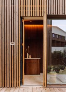 an open door to a building with wooden walls at Aethos Ericeira in Ericeira