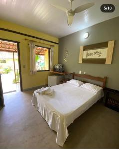 1 dormitorio con 1 cama blanca grande en una habitación en Pousada Embaubas en Serra do Cipo