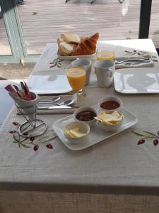 - une table avec une assiette de nourriture, du pain et des boissons dans l'établissement LA TOULOTTE chez Claire et Christian, à Sancy-lès-Provins