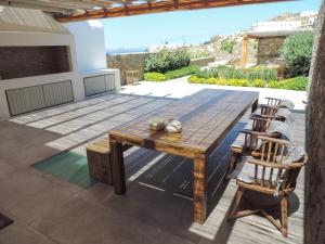 圖羅斯的住宿－Luxury Mykonos Villa - Stunning Seaviews - 4 Bedrooms - Jacuzzi - Agia Sofia Villa，庭院配有木桌和椅子