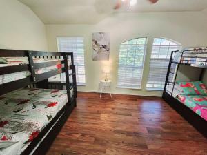 Habitación con 3 literas y mesa con lámpara. en Hot Tub! 4BR 3BA Modern, newly remodeled, 16 ppl, en McKinney