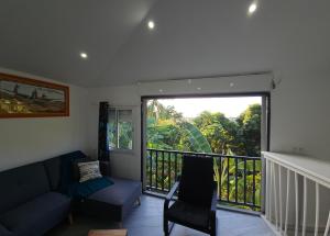 ein Wohnzimmer mit einem Sofa und einem Balkon in der Unterkunft Chez les Rakoto in Koungou