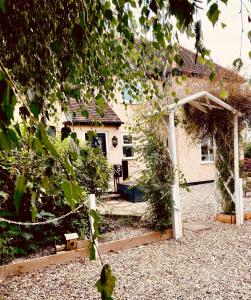 a garden with a white pergola in front of a house at Home from Home in our Self-Contained Annexe in Radwinter