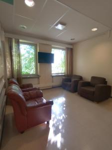 ein Wohnzimmer mit einem Sofa und Stühlen in einem Zimmer in der Unterkunft Hotelli Posti in Äänekoski