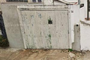 una porta bianca del garage con una pianta in vaso di Grandes Grupos Casa 2 a San Paolo