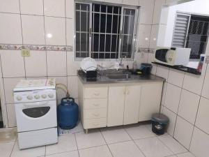 uma pequena cozinha com um fogão e um lavatório em Grandes Grupos Casa 2 em São Paulo