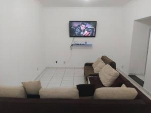 uma sala de estar com um sofá e uma televisão na parede em Grandes Grupos Casa 2 em São Paulo