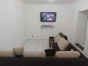 un soggiorno con un divano e una TV a parete di Grandes Grupos Casa 2 a San Paolo