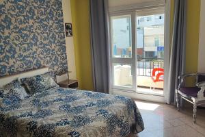 um quarto com uma cama, uma janela e uma cadeira em Ali's App Arts em Kenitra