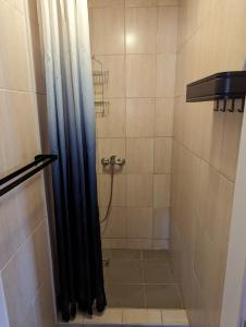 a shower with a black shower curtain in a bathroom at Hostel John Galt in Brno