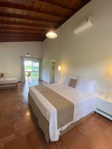 1 dormitorio con 1 cama blanca grande en una habitación en Vale Das Águas Fazenda Resort en Águas de Santa Barbara