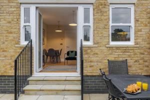 a patio with a table and chairs on a house at Modern 2 Bed Oasis - Private parking & Garden in Windsor