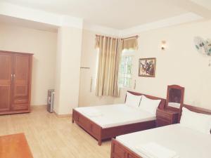 een woonkamer met 2 bedden en een raam bij KHÁCH SẠN CÚC PHƯƠNG (CÚC PHƯƠNG HOTEL) in Dĩ An