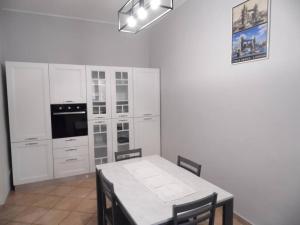 a kitchen with white cabinets and a table with chairs at La vecchia vite casa vacanze in Trevi