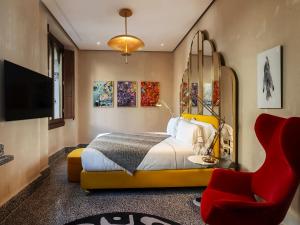 una camera con letto e sedia rossa di Hotel Calimala a Firenze