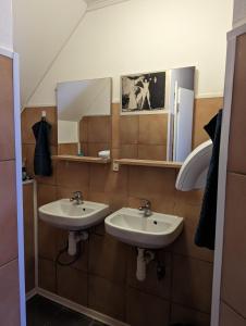 a bathroom with two sinks and a mirror at Hostel John Galt in Brno