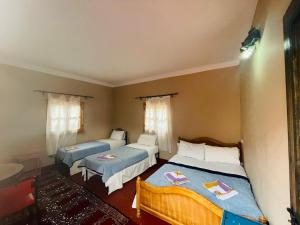 1 dormitorio con 2 camas en una habitación en Riad Les Roches Todra, en Tinerhir