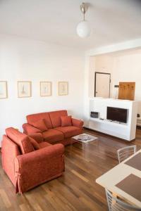 a living room with a red couch and a television at Appartamento in zona centrale DIMORA FIDUCIA in Pescara