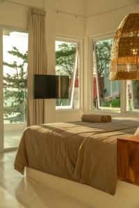 sypialnia z łóżkiem i dużym oknem w obiekcie The Peak Surf House w mieście Huu