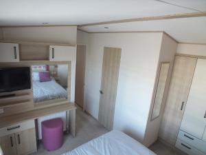 a bedroom with a bed and a tv in it at Beachside Lighthouse 14 in Lossiemouth
