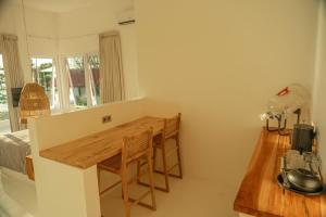 a small kitchen with a table and a bed at The Peak Surf House in Huu