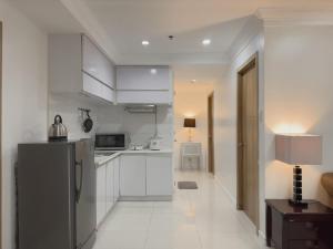 a kitchen with white cabinets and a stainless steel refrigerator at Magnificent View of Manila Bay, Roxas Blvd, US Embassy in Manila