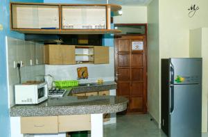 una pequeña cocina con encimera y nevera en Mei Place Apartments, en Mombasa