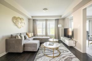 un soggiorno con divano e tavolo di GLOBALSTAY Modern 3 Bedroom House in Brampton a Brampton