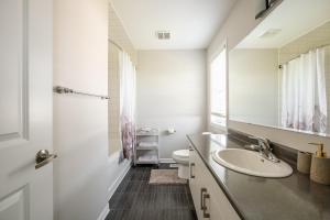 a bathroom with a sink and a toilet and a mirror at GLOBALSTAY Modern 3 Bedroom House in Brampton in Brampton