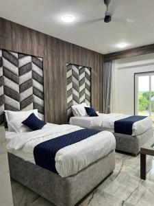 2 camas en una habitación de hotel con 2 camas sidx sidx sidx en Hotel krishna, en Nizāmābād