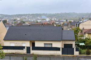 una casa con techo negro en una ciudad en BEAU T3 SPACIEUX PROCHE CENTRE ViLLE en Brive-la-Gaillarde