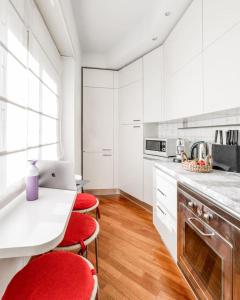 een keuken met rode stoelen en een laptop op een aanrecht bij Vatican Museum Apartment - Zen Real Estate in Rome