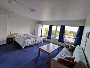 マンダールにあるSKAP Hostel Mandalのベッドルーム1室(ベッド2台、ソファ、テーブル付)