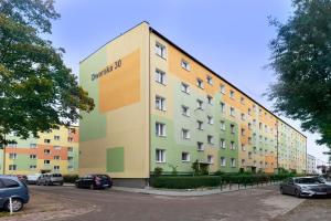 un gran edificio con coches estacionados en un estacionamiento en Elite Apartments Brzeźno Family, en Gdansk