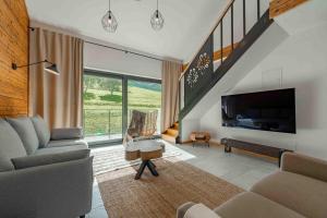een woonkamer met een bank en een tv bij Apartament Na Górce - Enklawa Pod Skrzycznem - Dream Apart in Szczyrk