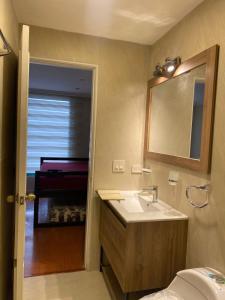 a bathroom with a sink and a mirror at Fontana: Location + Pool in Quito