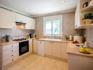 een keuken met witte kasten, een wastafel en een raam bij Holiday Home Villa Passera by Interhome in Orba