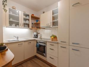 een keuken met witte kasten en een wastafel bij Apartment Smilla by Interhome in Bad Gastein