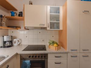 een keuken met witte kasten en een doos fruit op de toonbank bij Apartment Smilla by Interhome in Bad Gastein
