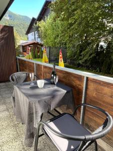 a table and chairs on a balcony with a table and wine glasses at Apartment Am Birkenhain-2 by Interhome in Seefeld in Tirol