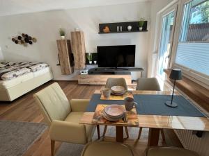 a living room with a table and chairs and a television at Apartment Am Birkenhain-2 by Interhome in Seefeld in Tirol