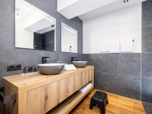 a bathroom with two vessel sinks on a wooden counter at Apartment Penthouse large Bergblick 19 by Interhome in Söll