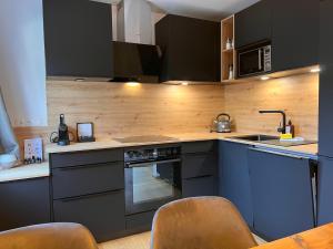 a kitchen with black cabinets and a stove top oven at Apartment Apartments Austria-2 by Interhome in Söll