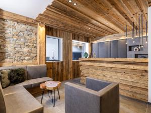 a living room with a couch and a stone wall at Apartment Superior Bergblick 2 by Interhome in Söll