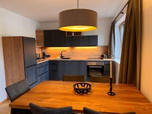 a kitchen with a wooden table with chairs and aendant light at Apartment Penthouse small 18 by Interhome in Söll