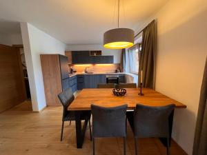 a kitchen and dining room with a wooden table and chairs at Apartment Penthouse small 18 by Interhome in Söll