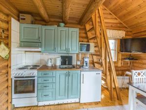 a kitchen with green cabinets in a log cabin at Holiday Home Kuukkelin tupa 1 by Interhome in Pyhätunturi