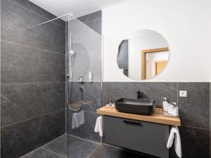 a bathroom with a shower with a sink and a mirror at Apartment Apartments Austria-5 by Interhome in Söll